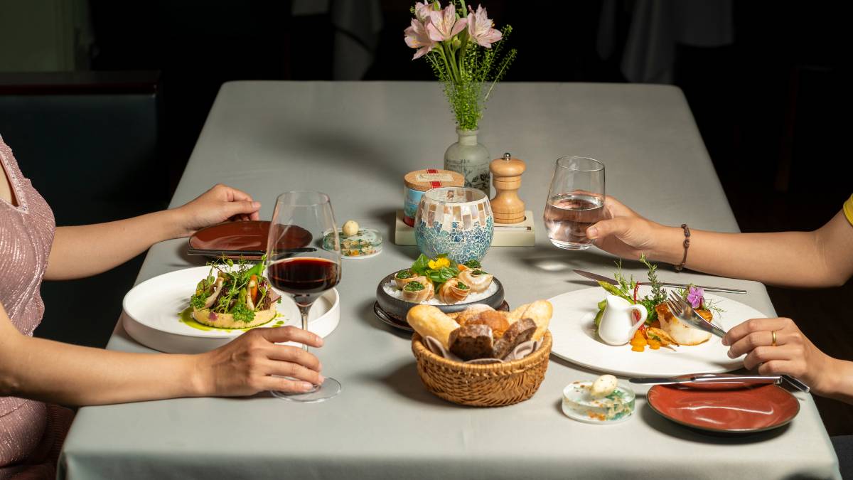 Cặp đôi dùng bữa tối lãng mạn tại nhà hàng Pháp The Temptation Đà Nẵng trong không gian biệt thự ánh nến